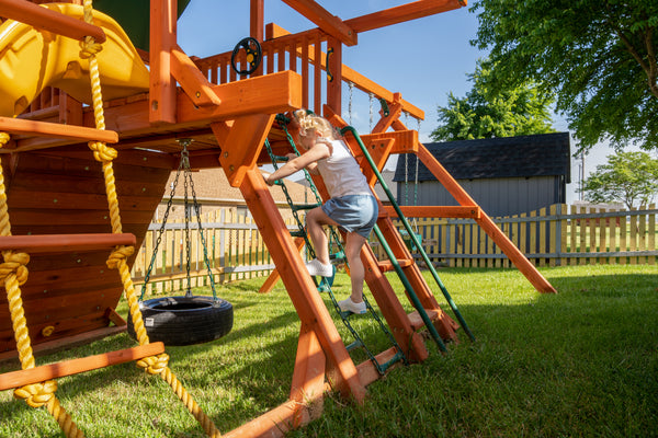 child climbing on wooden swing set ladder