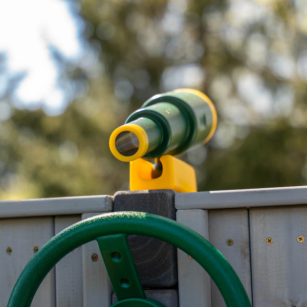 close up of telescope swingset accessory and a racing wheel swingset accessory on a playset
